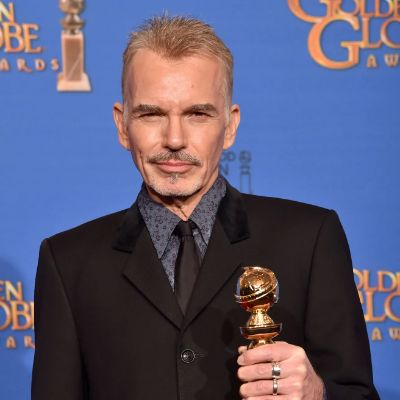 Billy Bob Thornton posing for a photo shoot while holding an award.
